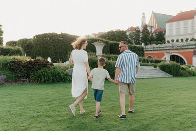 Full length of happy friends standing on grassy field