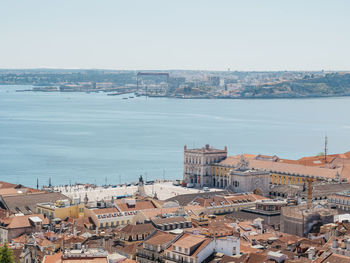 High angle view of townscape by sea against sky