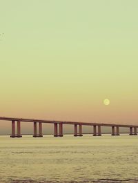 Scenic view of beach against clear sky during sunset