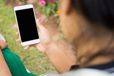 Midsection of woman using mobile phone outdoors