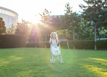 Cute girl with baby carriage at park