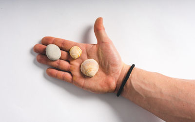 Close-up of hand holding ice cream over white background