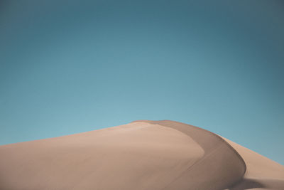 Scenic view of desert against clear blue sky