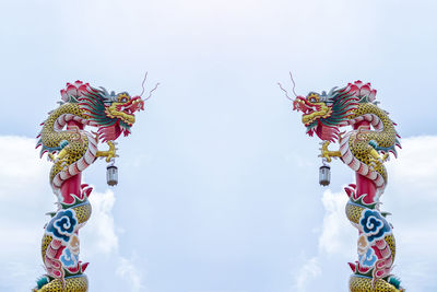 Low angle view of flowering sculpture against sky