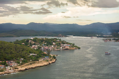 High angle view of city by sea against sky