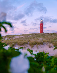 Lighthouse by sea against sky