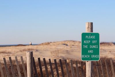 Warning sign on wooden post