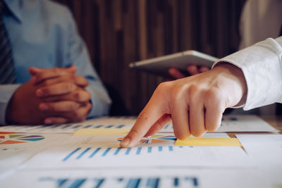 Midsection of man working with book on table