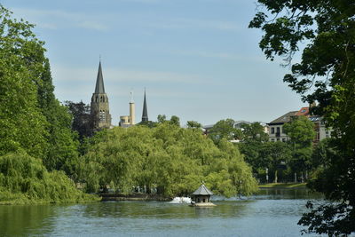 Scenic view of lake by buildings against sky