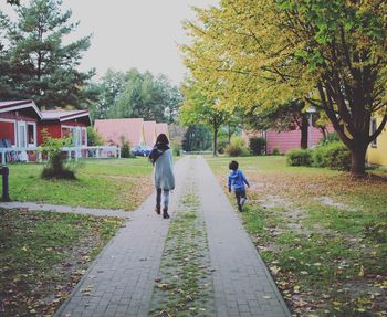 Rear view of people walking in park during autumn