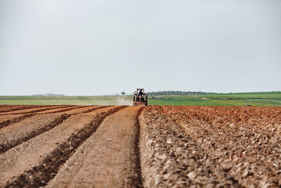 Scenic view of agricultural riding on field against sky