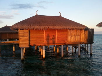 Wooden posts on beach against sky