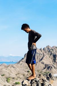Man standing on rock against mountain