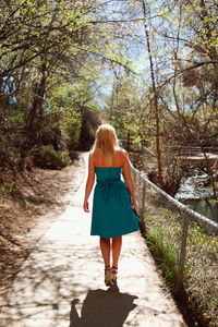 Rear view of woman walking on footpath