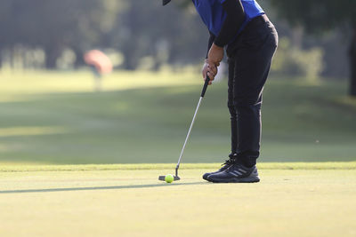 Low section of man playing golf