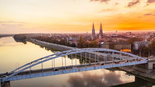 Bridge over river against sky during sunset