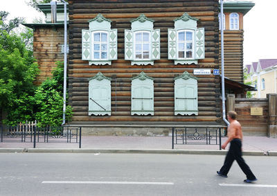 Full length of man walking on street against buildings in city