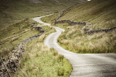 Scenic view of road by mountain against sky