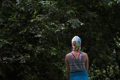 Rear view of woman standing in forest