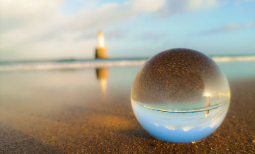 Close-up of illuminated light bulb on beach