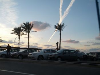 Cars on road against sky during sunset