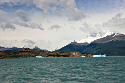 Scenic view of sea and mountains against sky