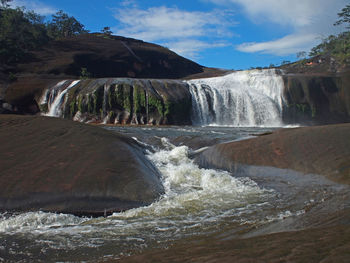 Scenic view of waterfall against sky at tham phra waterfall, bueng kan,  northeast of thailand