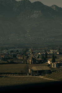 Aerial view of townscape on field by houses against sky