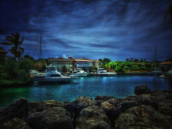 Boats in sea against cloudy sky