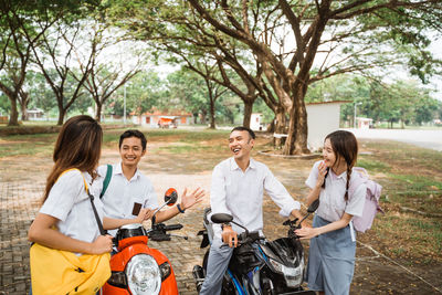 Portrait of smiling friends using digital tablet