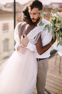 Young couple standing against wall