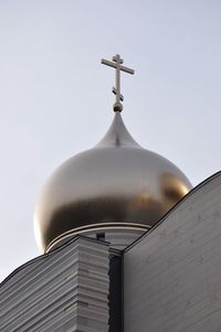 Low angle view of cross against building against clear sky