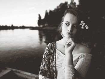 Close-up of thoughtful girl standing against lake