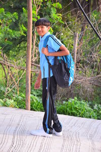 Full length of boy standing against plants