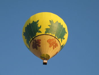 Low angle view of hot air balloon against clear blue sky