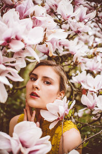 Portrait of young woman amidst pink flowers