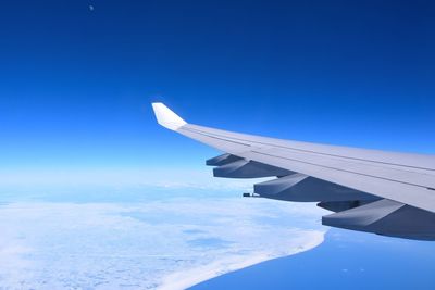 Airplane wing against clear blue sky