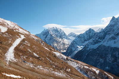 Scenic view of snowcapped mountains against blue sky