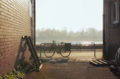 Bicycle by building against clear sky