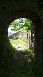 View of old ruin seen through arch window