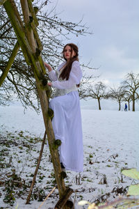 Woman standing on snow covered field, on a wood hunter place