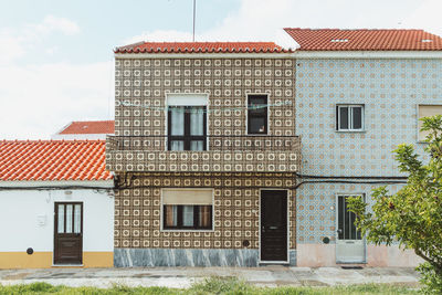 Exterior of house by building against sky