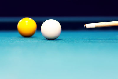 Close-up of balls and cue on pool table