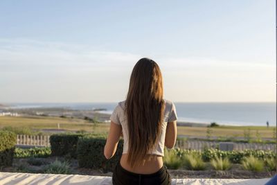 Woman looking at sea against sky