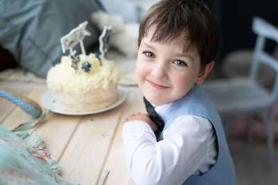 Portrait of cute boy with cake on table