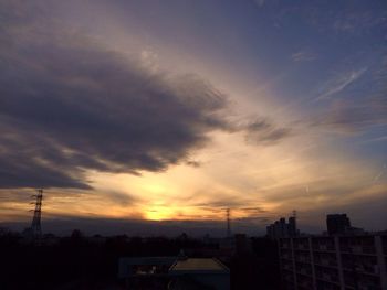 Silhouette of trees against cloudy sky at sunset