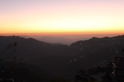 Scenic view of silhouette mountains against sky at sunset