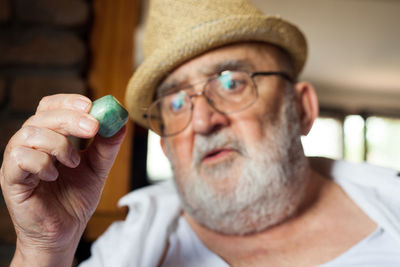 Close-up of senior man looking at pebble