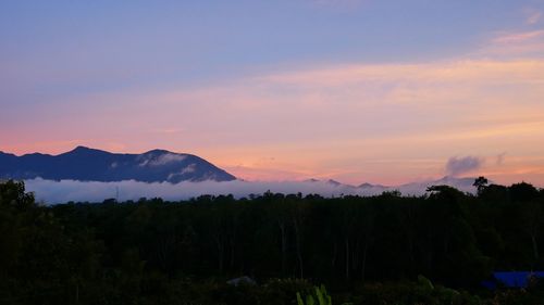 Scenic view of silhouette mountains against orange sky