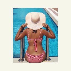 Rear view of woman with hat on swimming pool